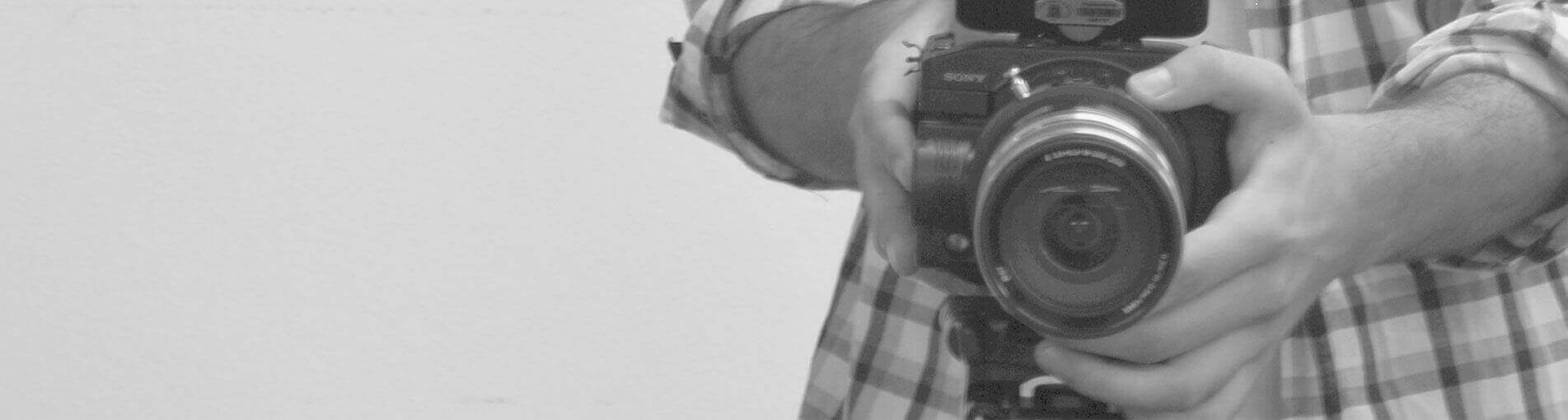 Imagem com uma pessoa segurando uma camêra fotográfica